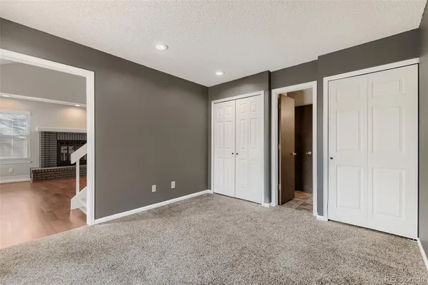 an empty room with closet and a chandelier fan