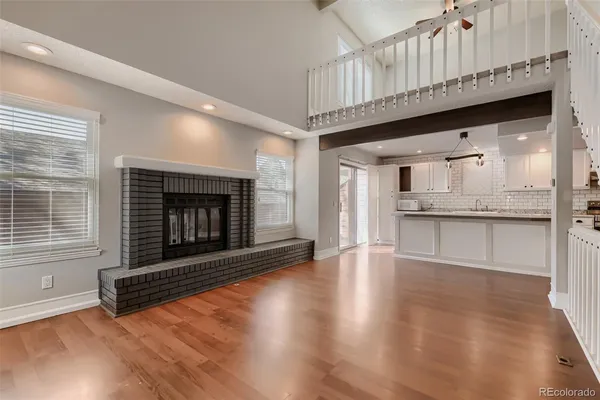 a living room with granite countertop wooden floor a fireplace and a window