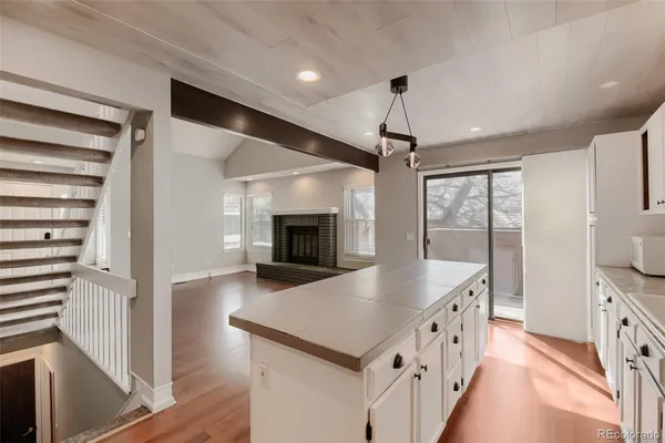 a kitchen with a sink a center island cabinets and a window