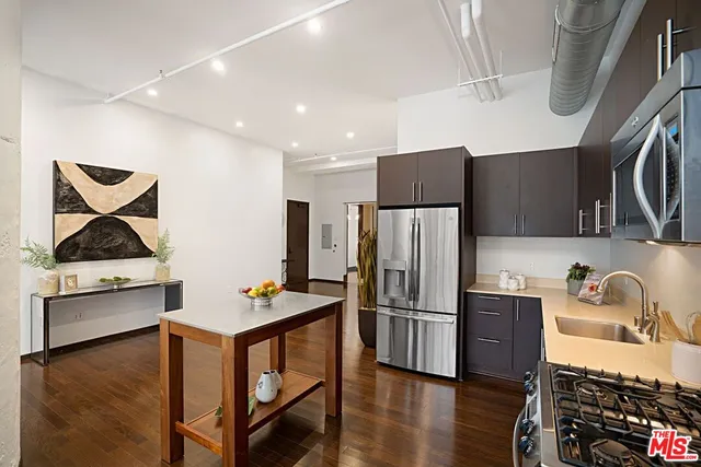 a kitchen with stainless steel appliances granite countertop a refrigerator sink and stove