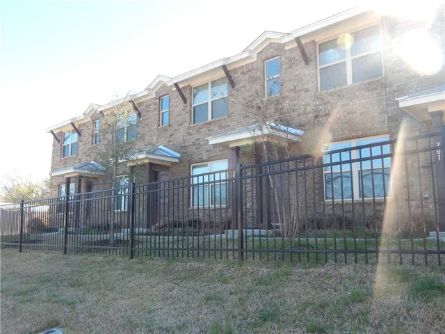 a view of a brick building next to a big yard
