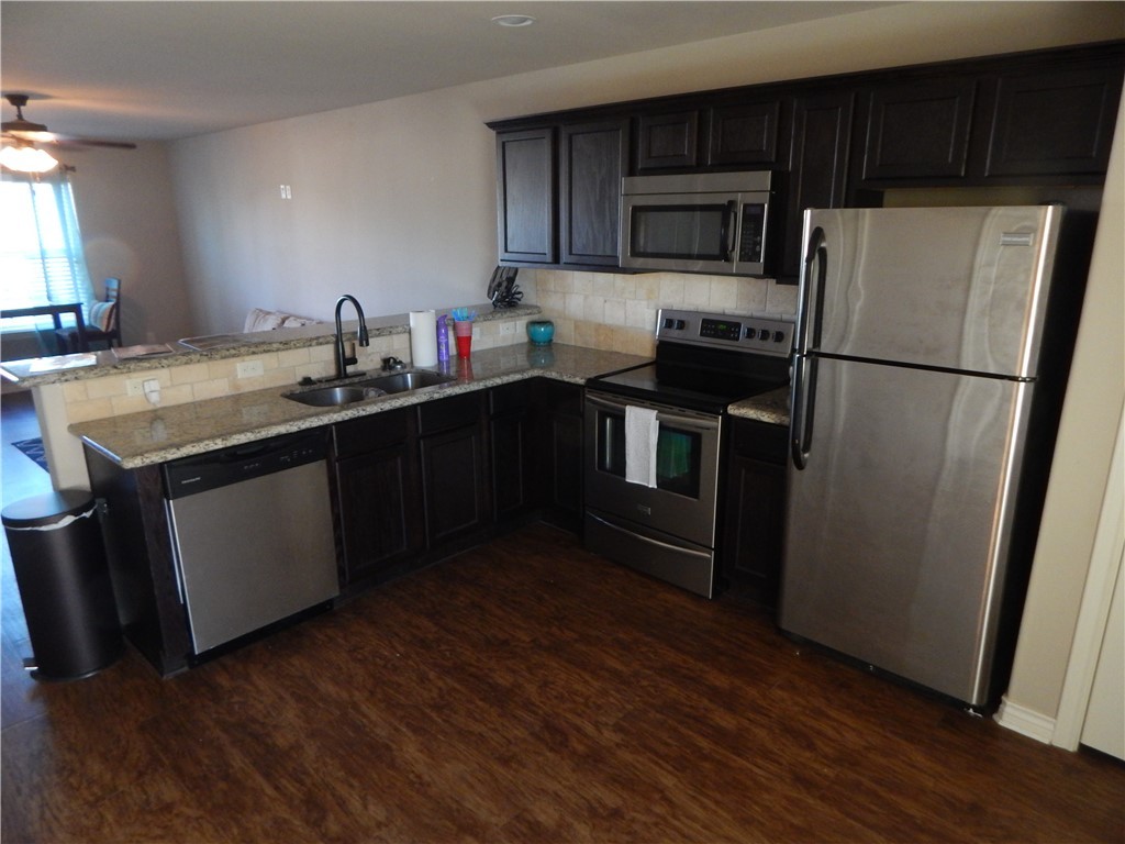 3500 South College Avenue, Unit 204 Bryan, TX 77801 - Photo 3 of 7 a kitchen with a sink a microwave a refrigerator and wooden floors