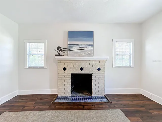 a living room with a fireplace and wooden floor