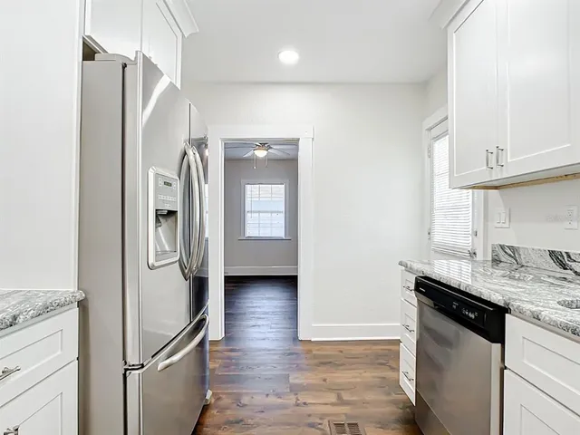 a kitchen with stainless steel appliances granite countertop a refrigerator and a sink