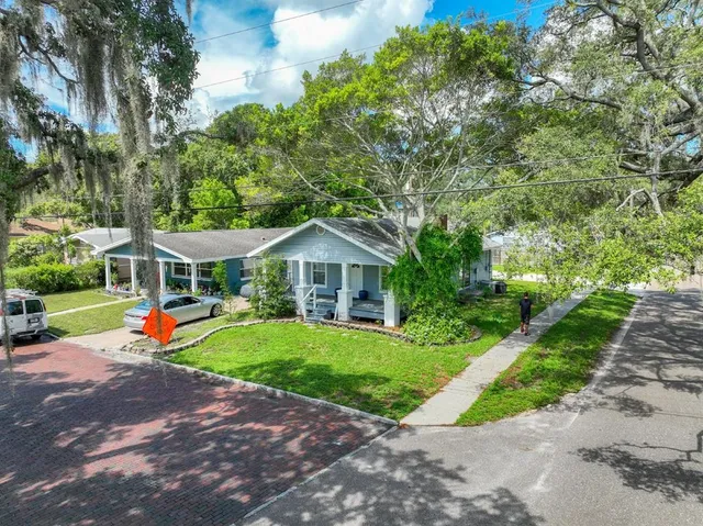 a front view of a house with a yard and potted plants