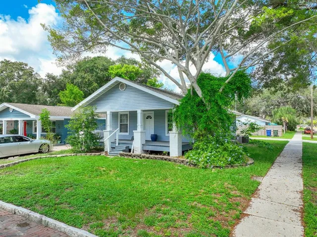 a front view of house with a garden and trees