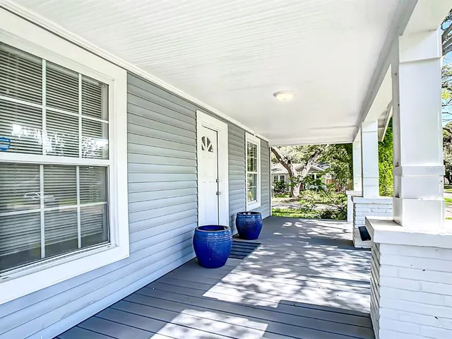 a view of a porch with wooden floor and a yard