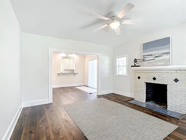 an empty room with windows and fireplace