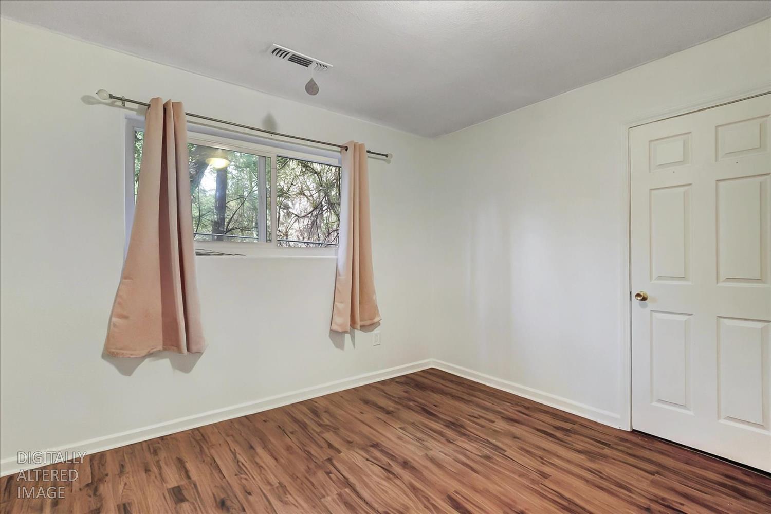 11312 Alpine Lane Grass Valley, CA 95945 - Photo 21 of 69 an empty room with wooden floor and windows