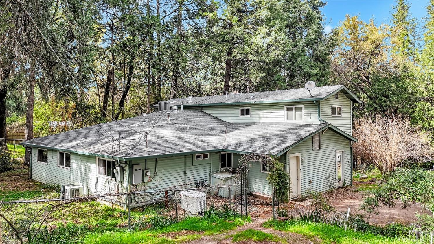 11312 Alpine Lane Grass Valley, CA 95945 - Photo 33 of 69 a backyard of a house with table and chairs under an umbrella