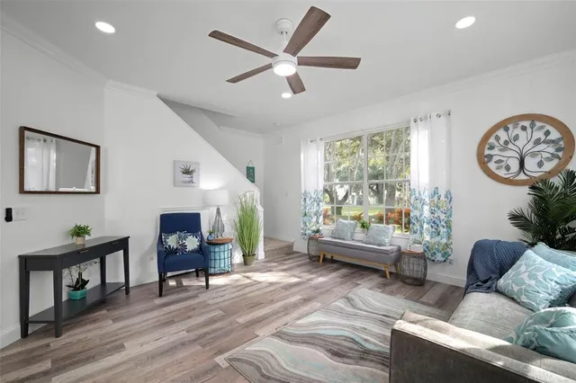 a living room with stainless steel appliances furniture a rug and a view of kitchen