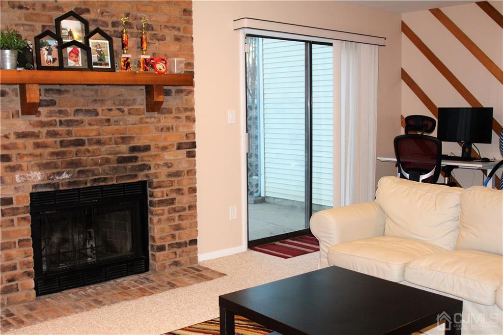 4602 Stonehedge Road, Unit 4602 Edison, NJ 08820 - Photo 24 of 25 a living room with furniture a fireplace and a flat screen tv