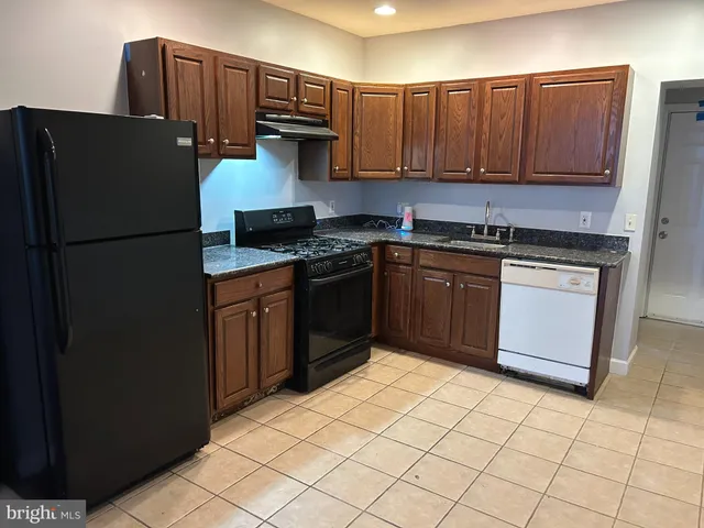 a kitchen with stainless steel appliances granite countertop a refrigerator stove a sink and dishwasher