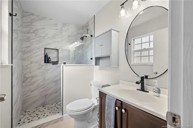 a bathroom with a sink a toilet and a mirror