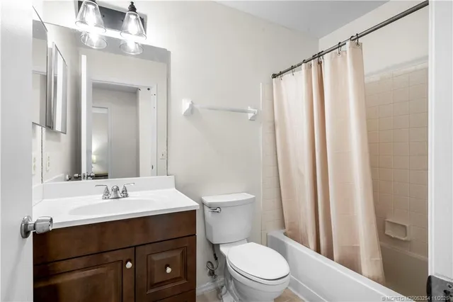 a bathroom with a sink a toilet a mirror and shower