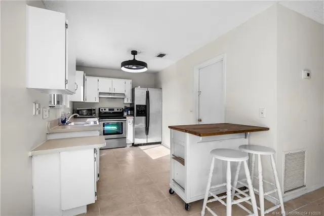 a kitchen with a stove a sink and cabinets