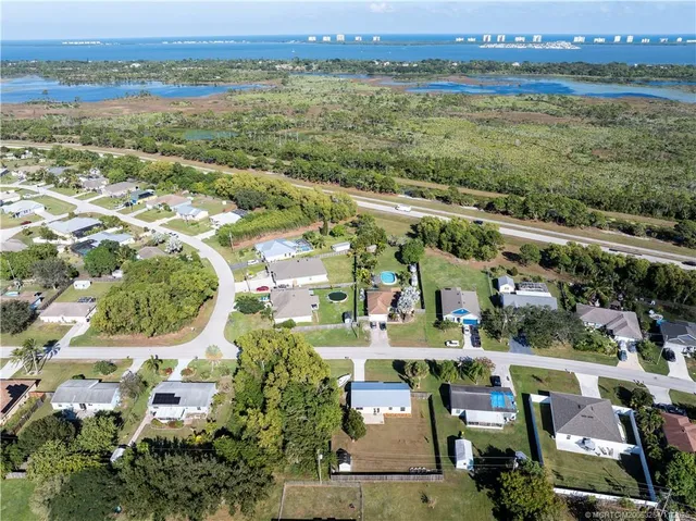 an aerial view of residential houses with outdoor space and swimming pool