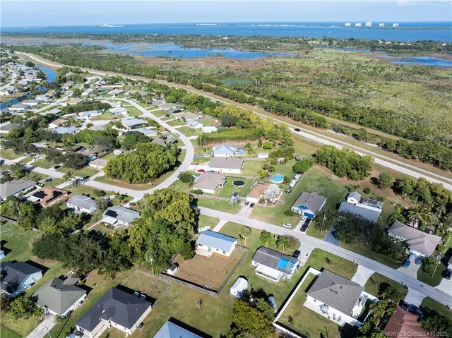an aerial view of residential houses with outdoor space and ocean view