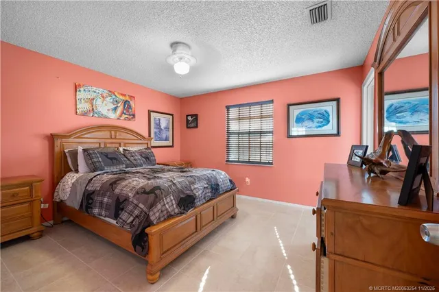 a bedroom with a bed and a dresser next to a window
