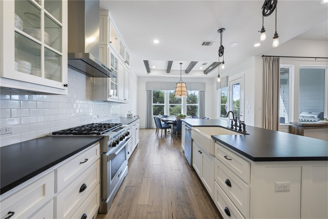 a kitchen with granite countertop a sink a counter top space stainless steel appliances and a window