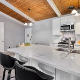 a kitchen with stainless steel appliances a white table chairs and a refrigerator