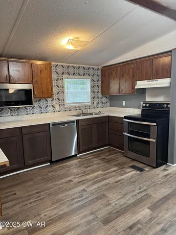 a kitchen with stainless steel appliances granite countertop a sink and cabinets