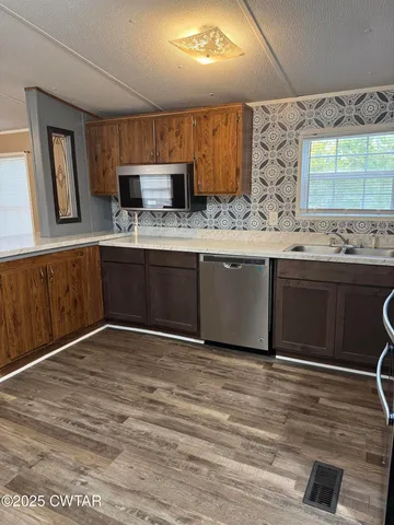 a kitchen with stainless steel appliances granite countertop a sink and a stove