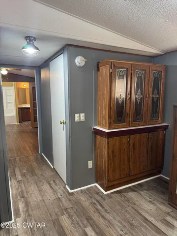 a view of a hallway with wooden floor and stairs
