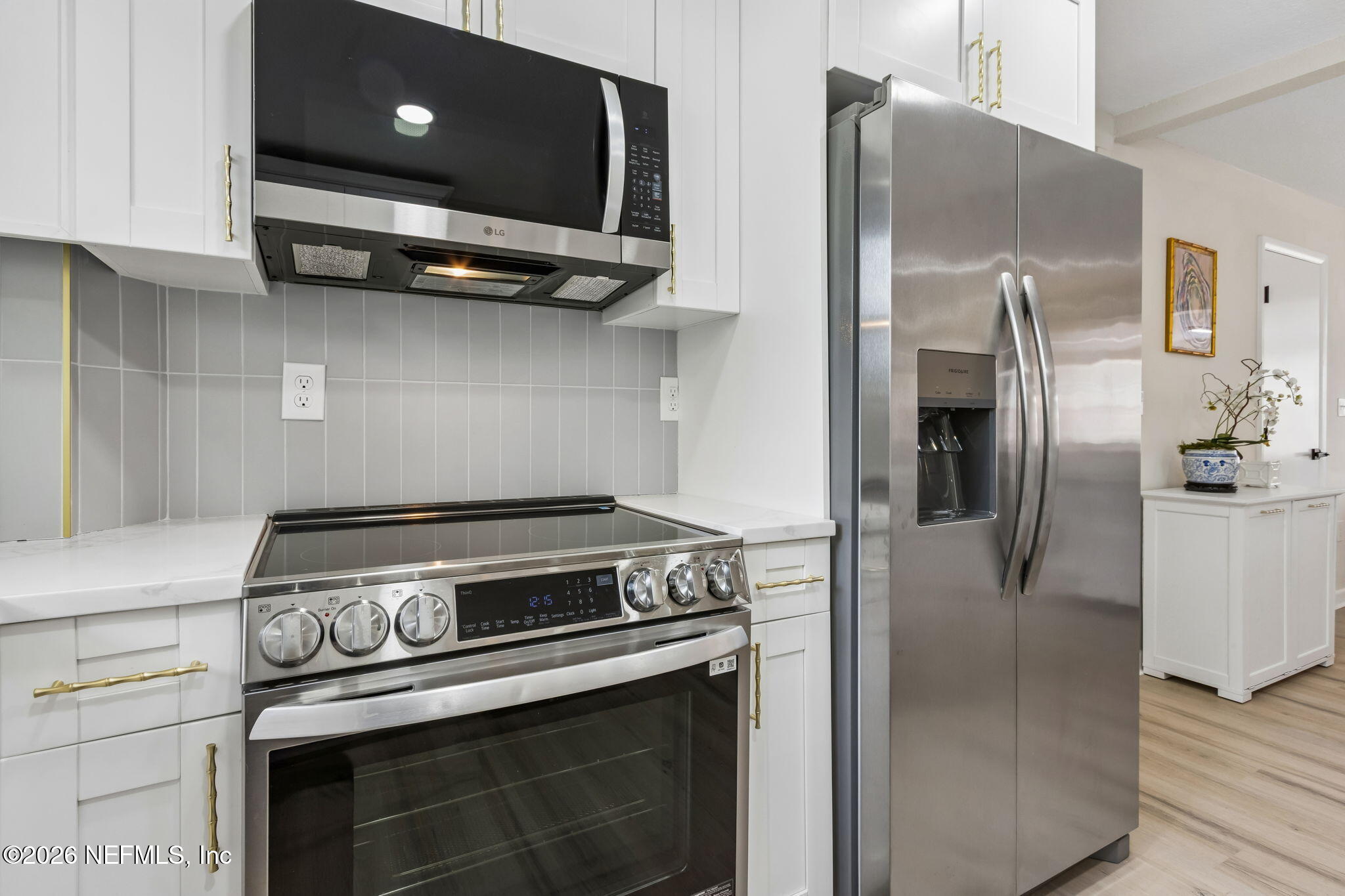 3668 Marianna Road Jacksonville, FL 32217 - Photo 11 of 27 a kitchen with stainless steel appliances granite countertop a refrigerator a stove and a sink with wooden floor