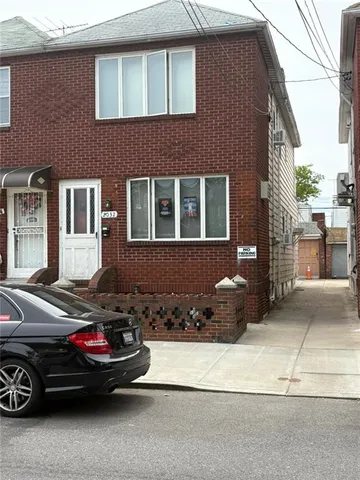 a car parked in front of a brick house