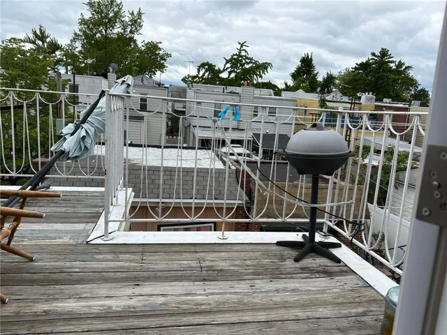 a view of a balcony with wooden floor and iron fence