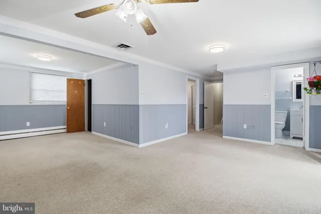 an empty room with chandelier fan