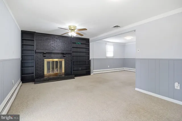a view of an empty room with a fireplace and a window
