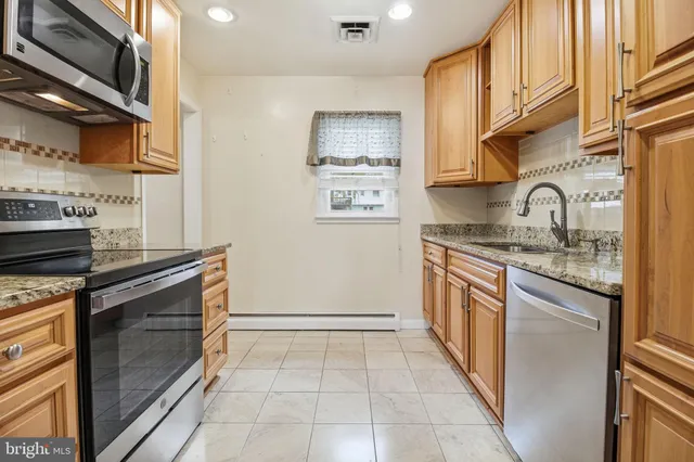 a kitchen with stainless steel appliances granite countertop a stove and a sink