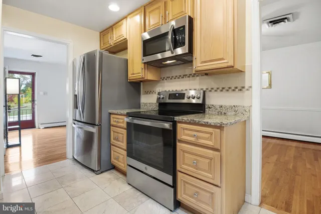 a kitchen with stainless steel appliances granite countertop a refrigerator stove and microwave