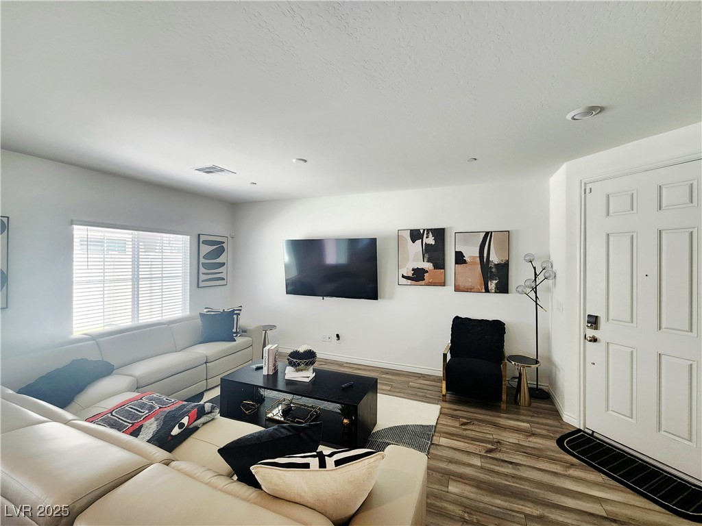 Living room featuring dark wood-style floors and a textured ceiling