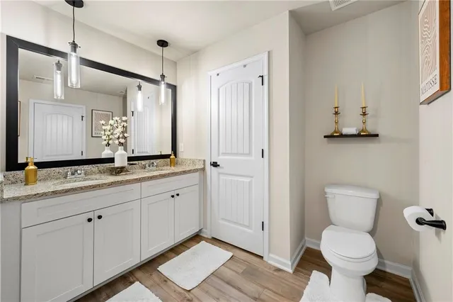 a bathroom with a granite countertop sink mirror vanity and toilet