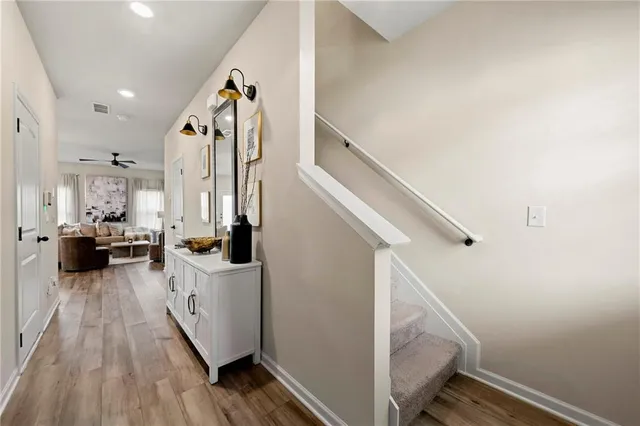 a view of hallway with wooden floor and staircase