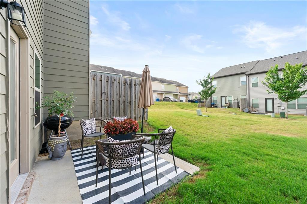 7098 Chara Lane Atlanta, GA 30331 - Photo 24 of 25 a view of a patio with table and chairs potted plants and palm tree