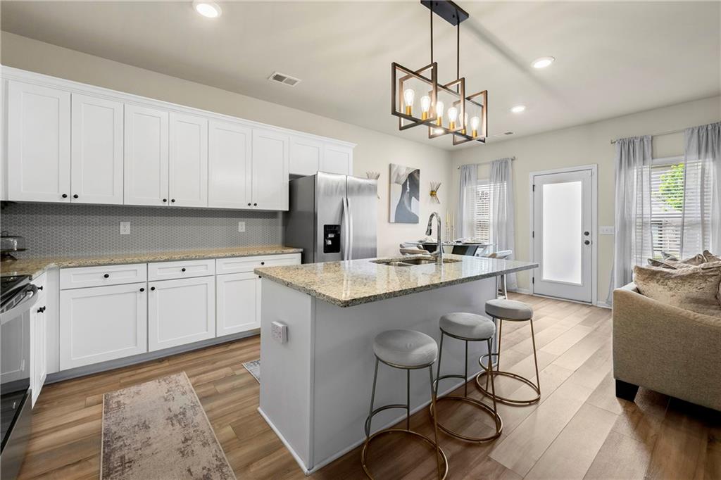 7098 Chara Lane Atlanta, GA 30331 - Photo 7 of 25 a view of a kitchen area kitchen island dining table and wooden floor