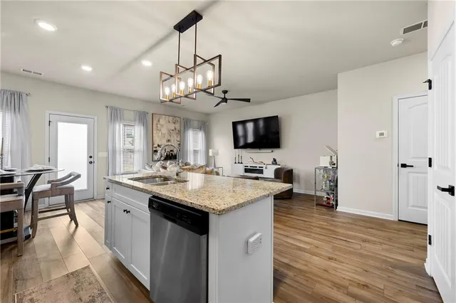 a kitchen with granite countertop white cabinets and stainless steel appliances