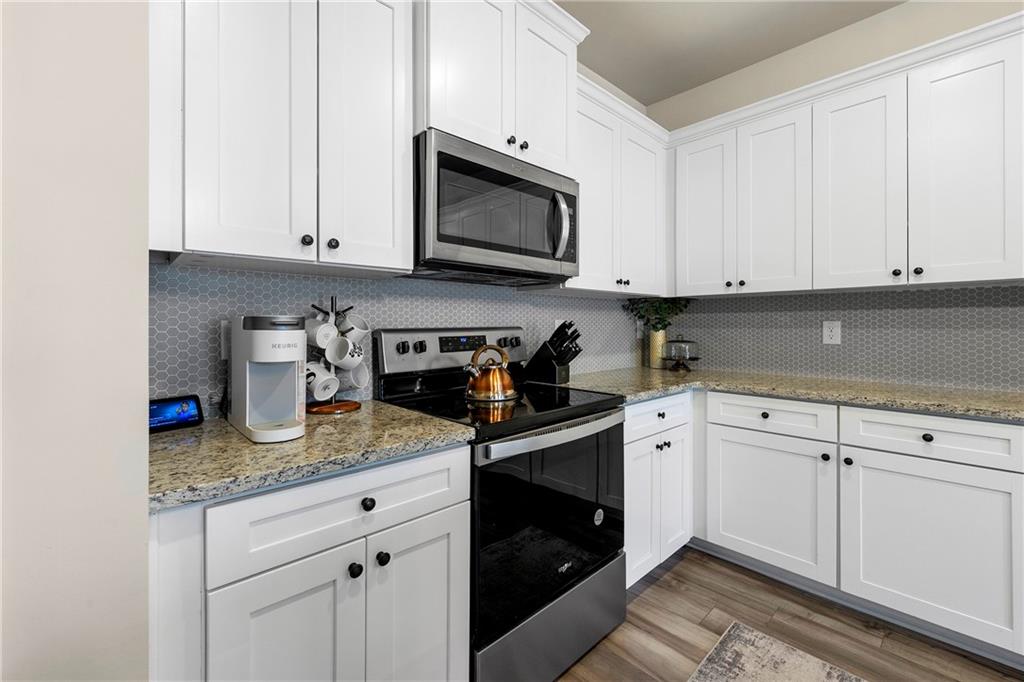 7098 Chara Lane Atlanta, GA 30331 - Photo 9 of 25 a kitchen with granite countertop white cabinets and stainless steel appliances