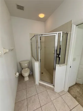 a bathroom with a granite countertop shower a toilet and a sink