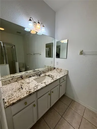 a bathroom with a granite countertop sink a large mirror and vanity