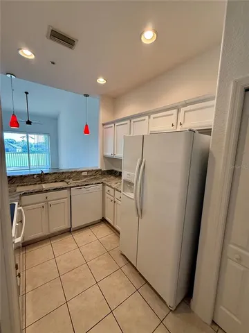 a kitchen with granite countertop a refrigerator and a sink