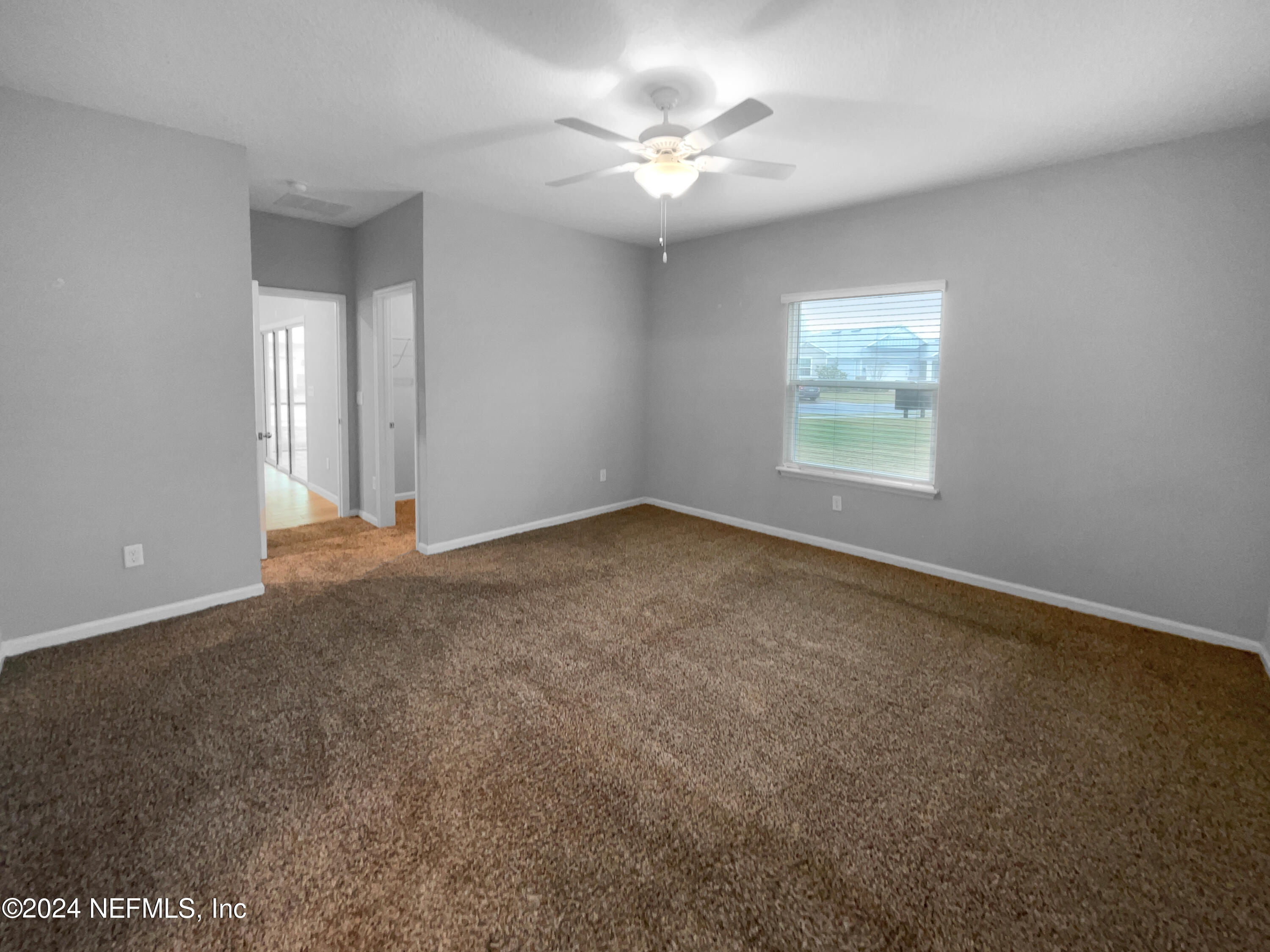 188 Bloomfield Way St. Augustine, FL 32092 - Photo 5 of 18 an empty room with windows and fan