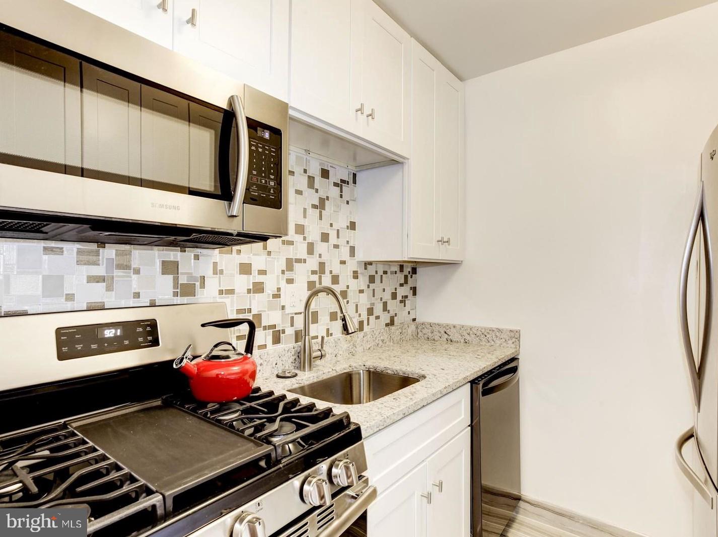2400 41st Street Northwest, Unit 203 Washington, DC 20007 - Photo 12 of 24 a kitchen with a stove and a microwave