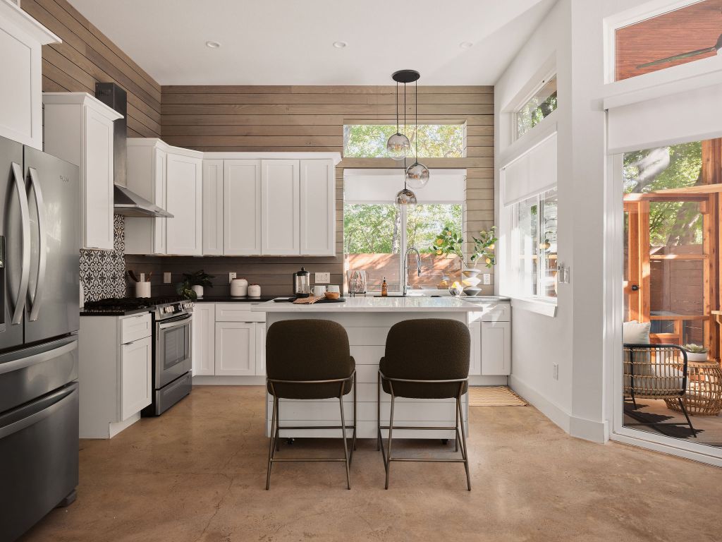 2806 Lyons Road, Unit 1 Austin, TX 78702 - Photo 15 of 39 a kitchen with stainless steel appliances granite countertop a stove a sink a refrigerator with a dining table and chairs