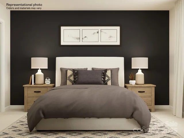 a bed sitting in a bedroom and dressers next to a window