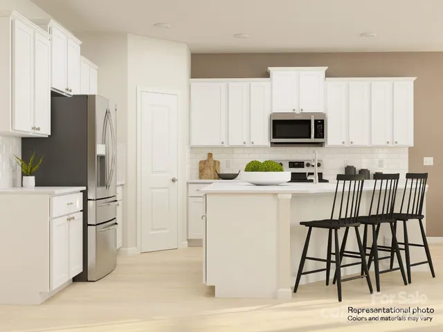 a kitchen with a refrigerator a stove top oven a sink and cabinets